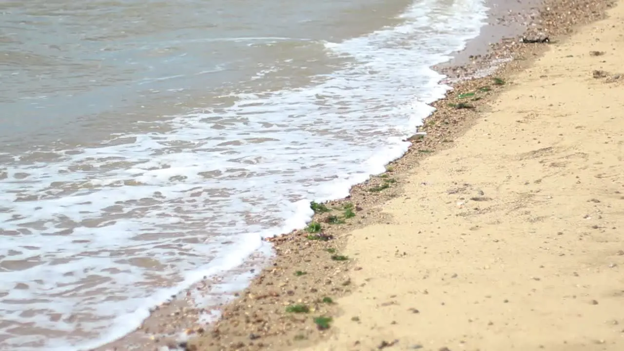 Waves crashing onto a sandy and rocky beach