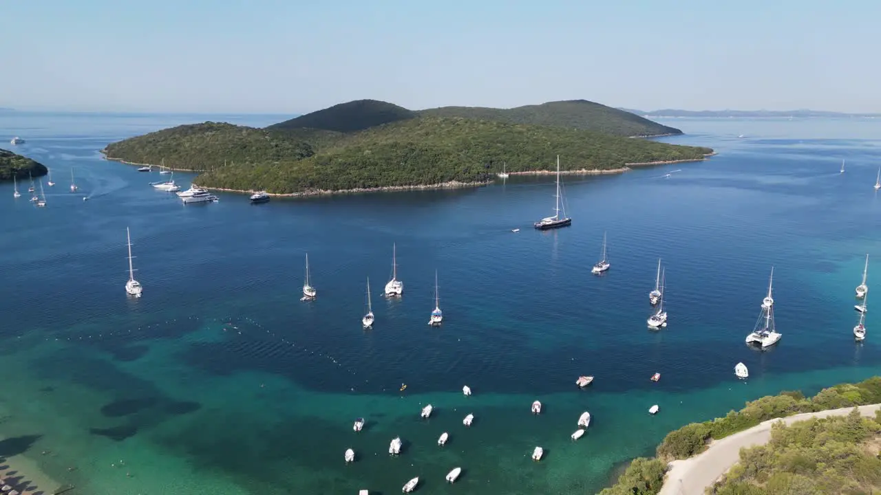 Boats sail near Syvota Coast and Green Island in Ionian Sea at Epirus Greece Aerial