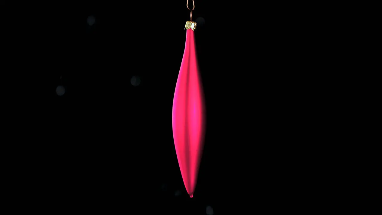 single red Christmas cone ornament with black background close up