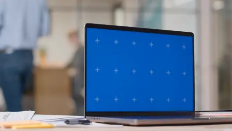 Blue Screen Laptop On Desk In Busy Modern Office 3