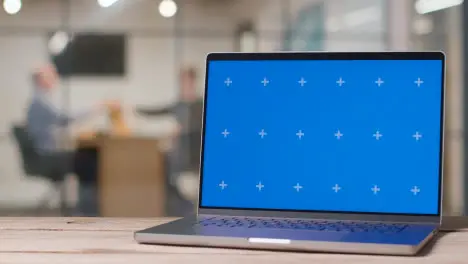 Blue Screen Laptop On Desk In Busy Modern Office 1