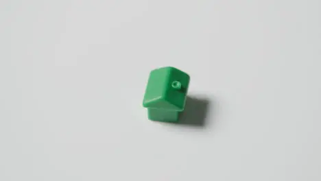 Home Buying Concept With Green Plastic Model Of House Revolving On White Background