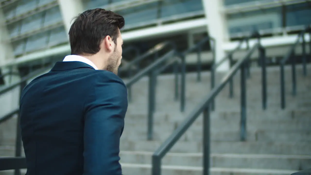 Portrait businessman walking upstairs near stadium Man looking away outdoors