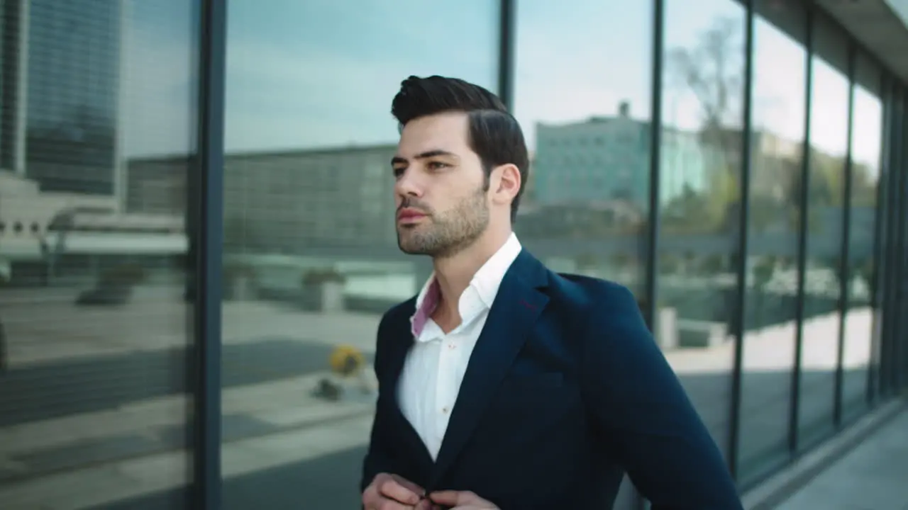 Portrait businessman walking in suit Man checking time on wrist watch outside