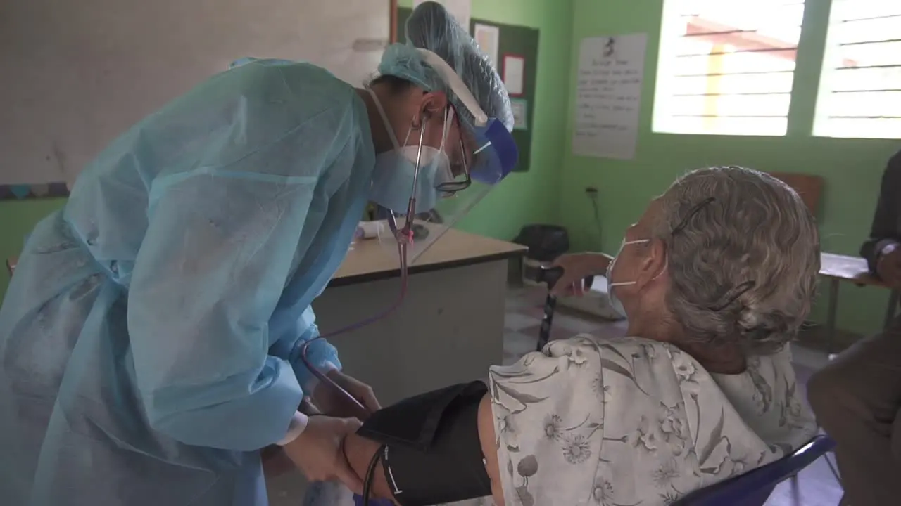 Doctor in a poor community examines a senior woman with a blood pressure meter and a stethoscope