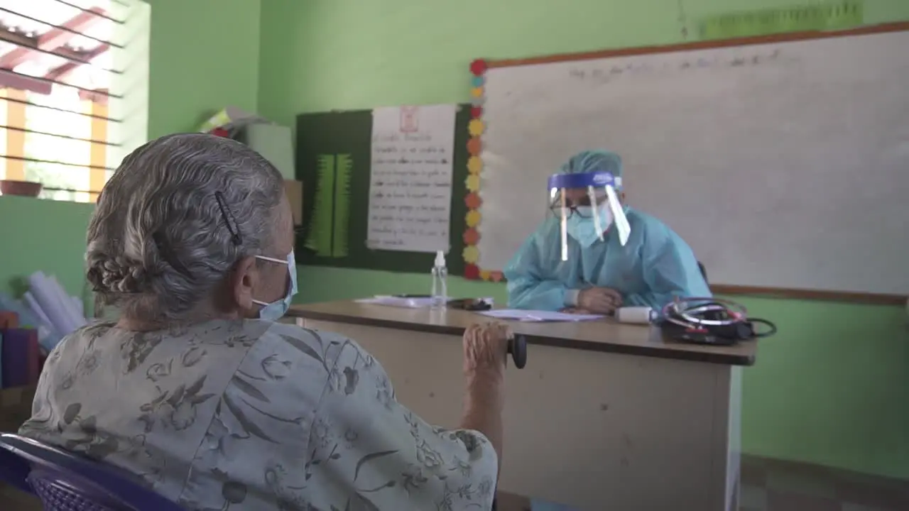 Older adult woman during a clinical consultation in a medical brigade in a school in a poor community in Honduras