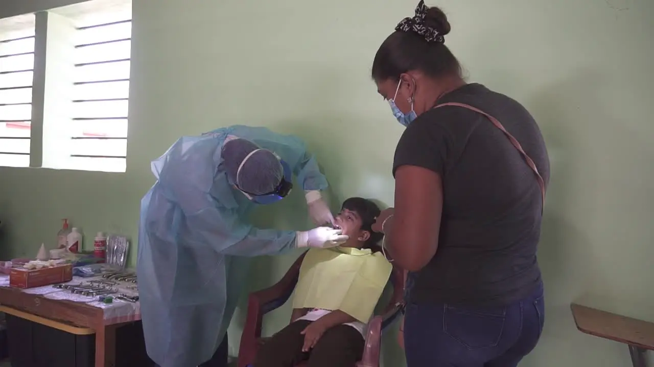 Dentist woman inspects mouth and teeth of a small child during consultation in mobile medical brigade