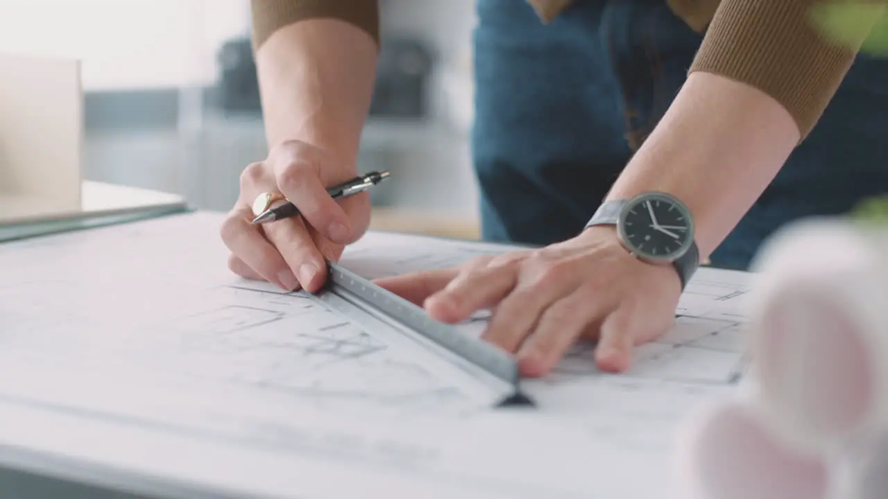 Close Up Of Male Architect In Office Drawing On Plan Or Blueprint With Ruler