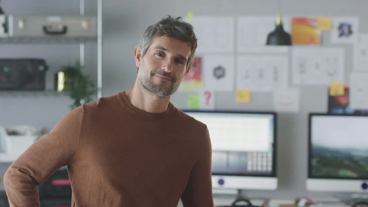 Portrait Of Smiling Mature Businessman Working In Creative Office