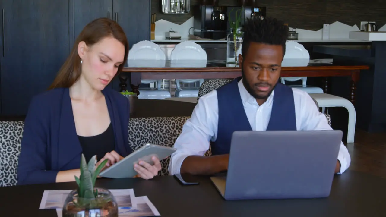 Front view of Young cool mixed-race business team working on multimedia devices in a modern office 4