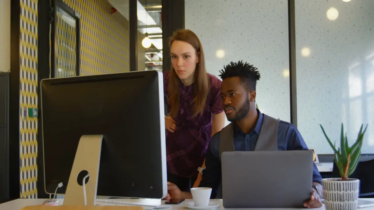 Front view of young cool mixed-race business team planning and working at desk in a modern office 4k