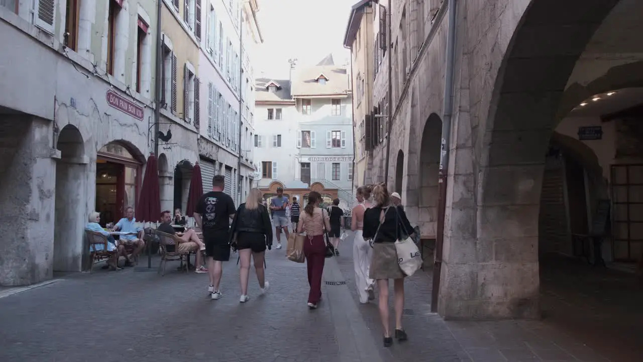 People walking and talking on the street in Annecy France an old quarter with arched passageway