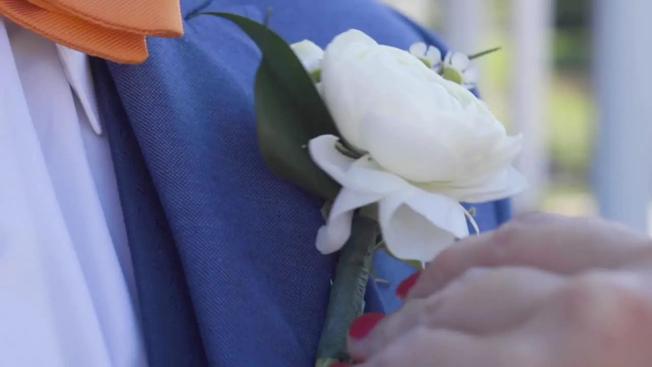 Groom getting flowers pinned before ceremony