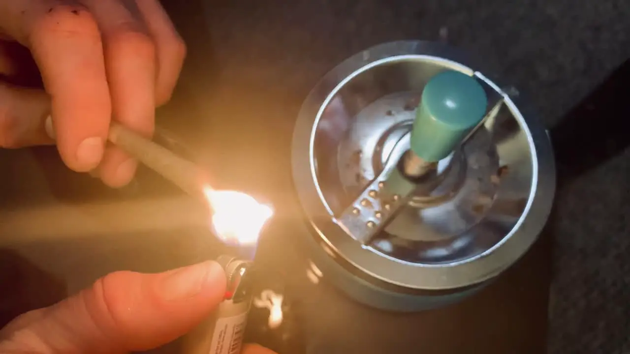 Cropped view of man lighting up blunt with medical cannabis