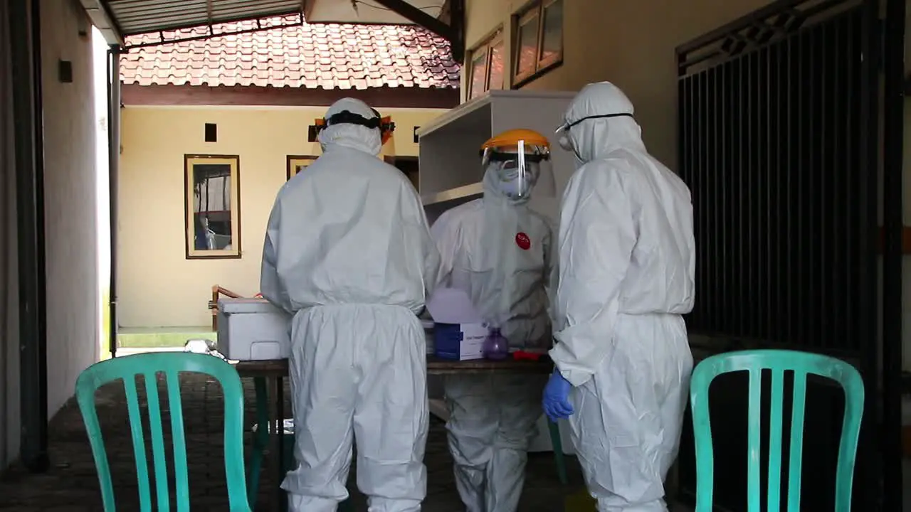 doctor in a protective suit taking a nasal swab from a person to test for possible coronavirus infection