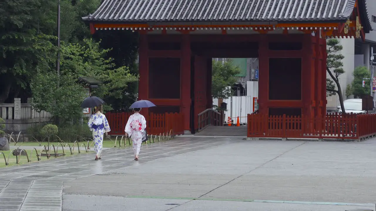 Two women wearing traditional Japanese Kimono walking on a rainy day near Senso-ji shrine in Asakusa Tokyo