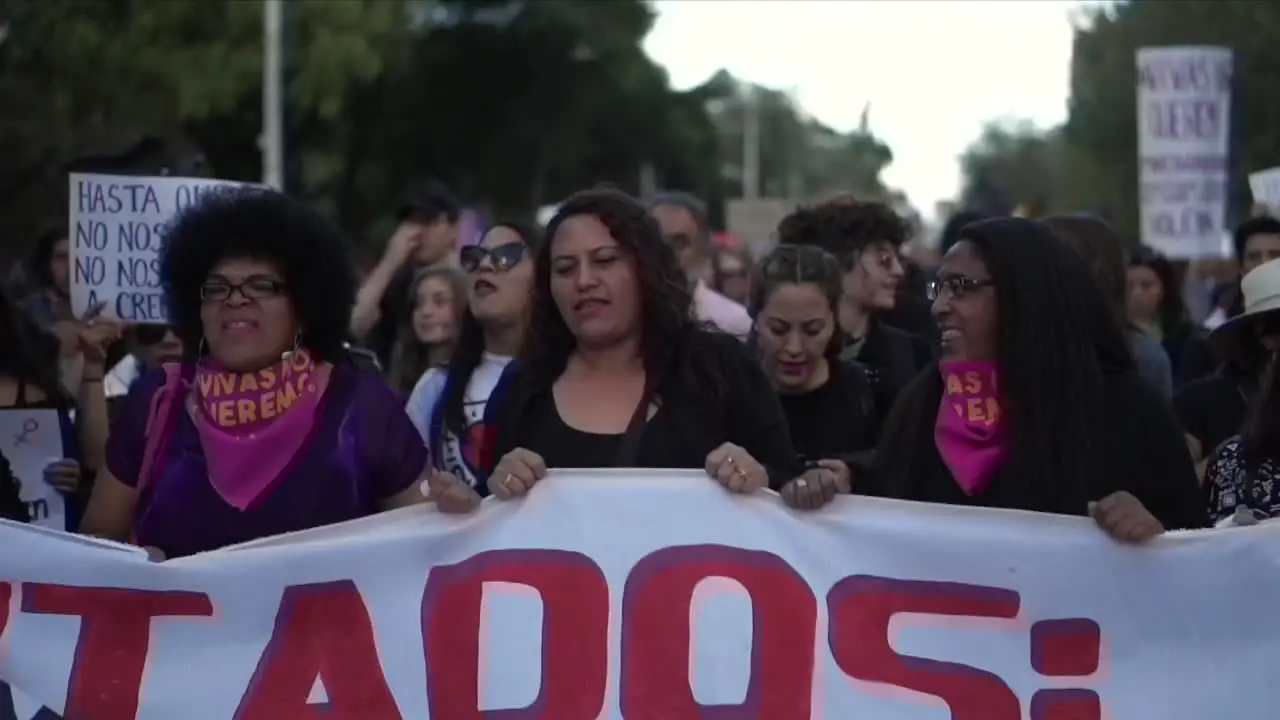 A group of women hold a banner in a peaceful protest against inequality