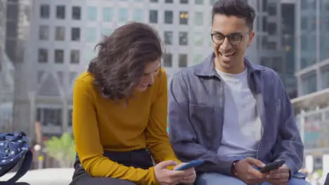 Arc Shot of Two Students Talking and Laughing with City Backdrop