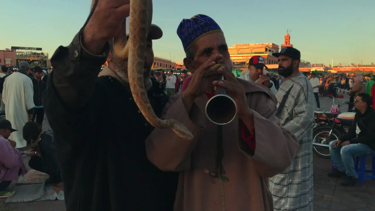 Medium shot of two snake charmers at Djemaa el Fna Marrakesh Morocco