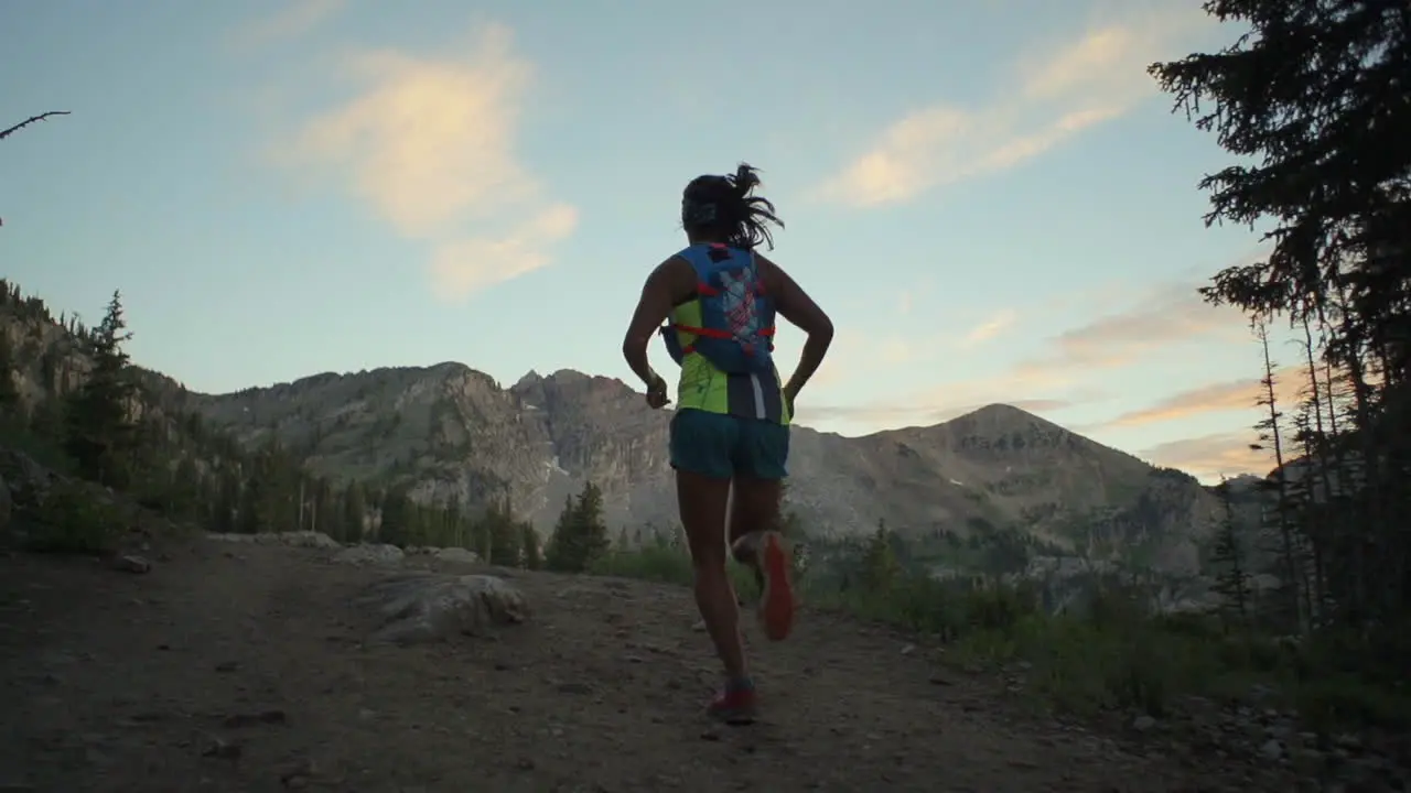 A woman is running uphill in the wilderness