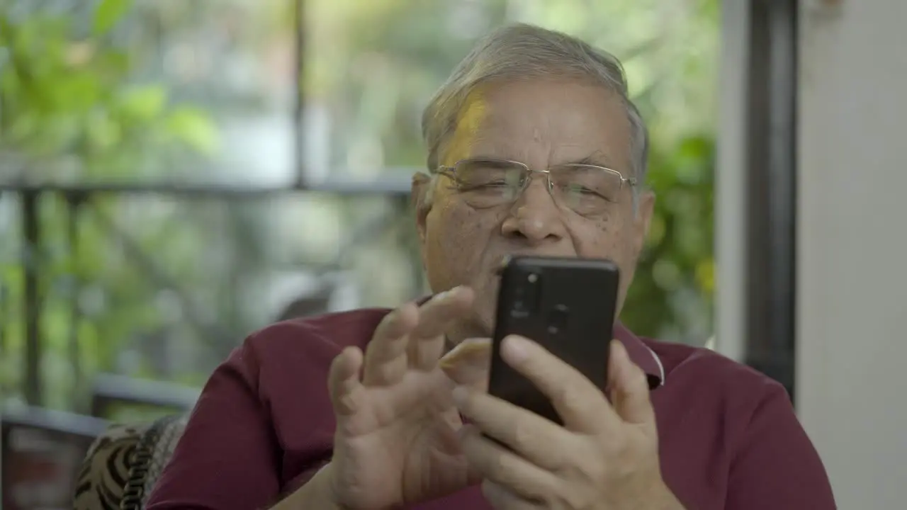 Old Asian Indian male using mobile phone