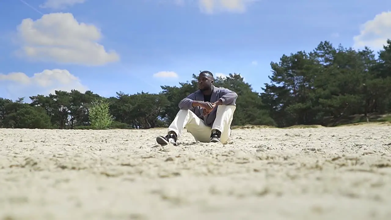 Young man sitting on a deserted beach relaxing and thinking