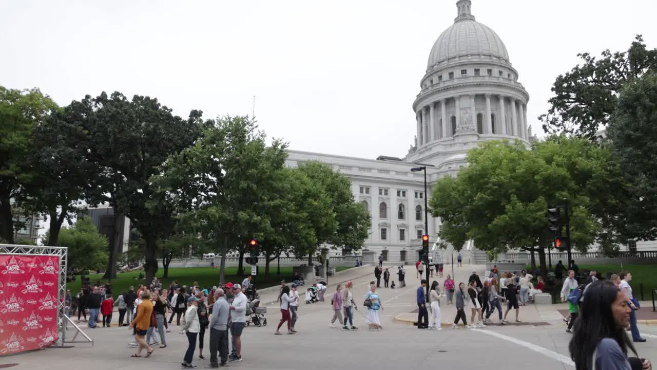 A group of people walking around the grounds at the state capitol building in Madison Wisconsin