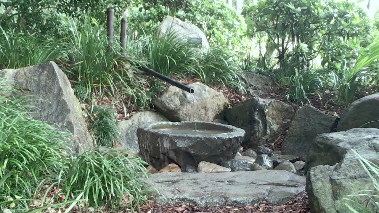 Water flowing into small concrete bowl Japanese Gardens Brisbane Queensland