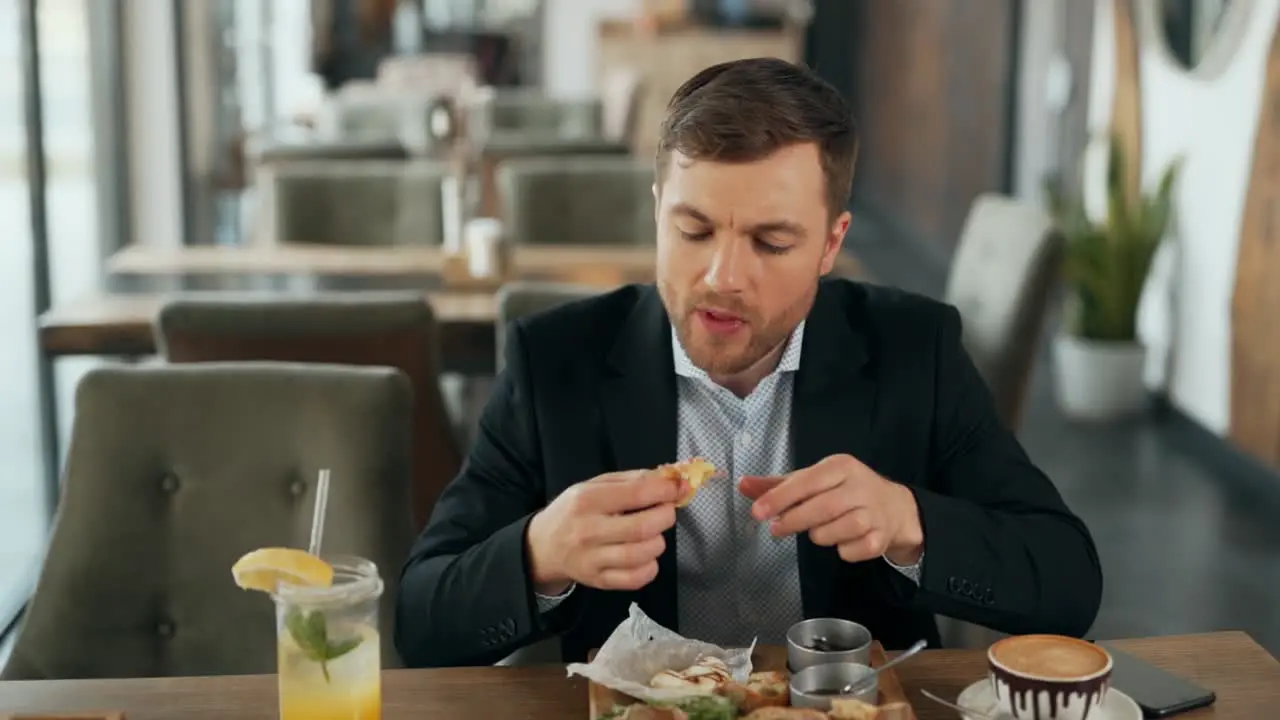 Charismatic man happy to eat grilled Camembert cheese with his hands