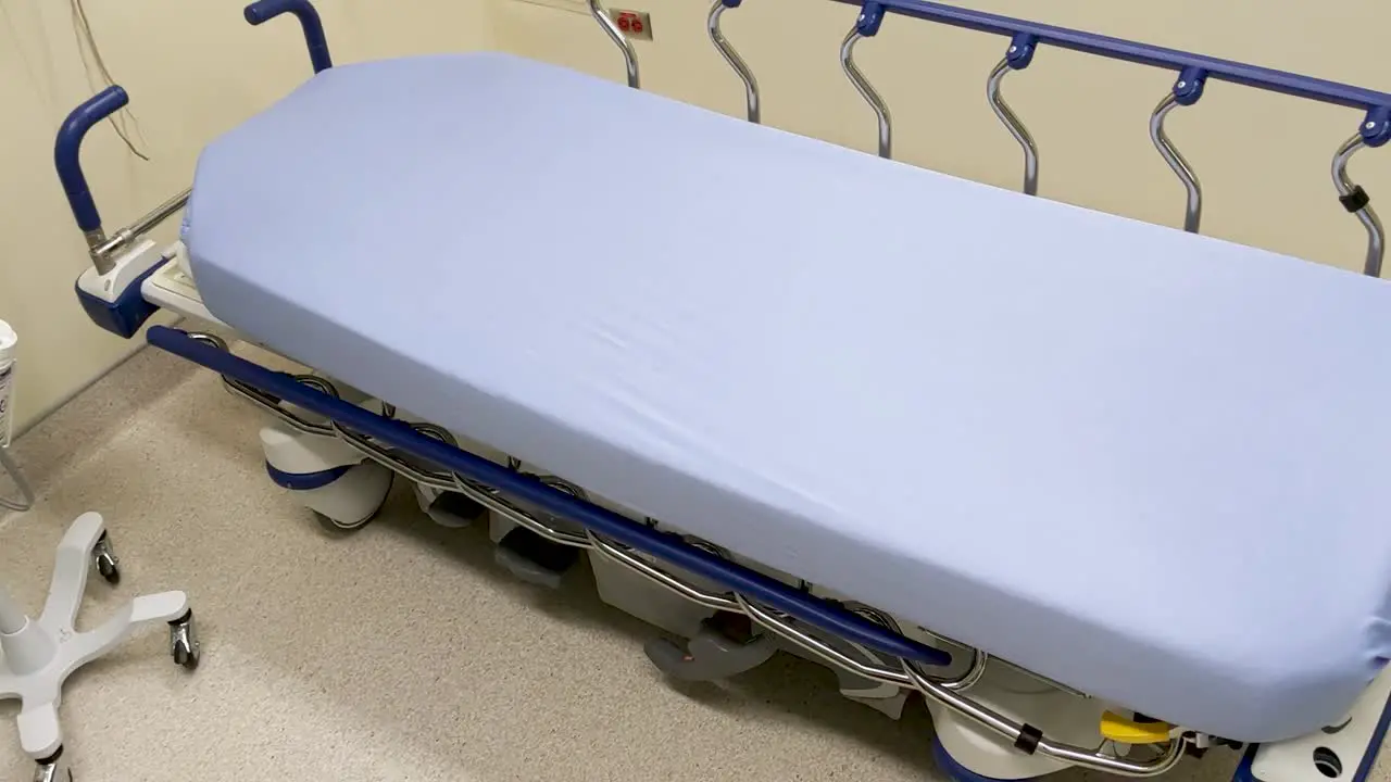 An empty hospital bed waiting a patient in a clean well prepared hospital assessment room