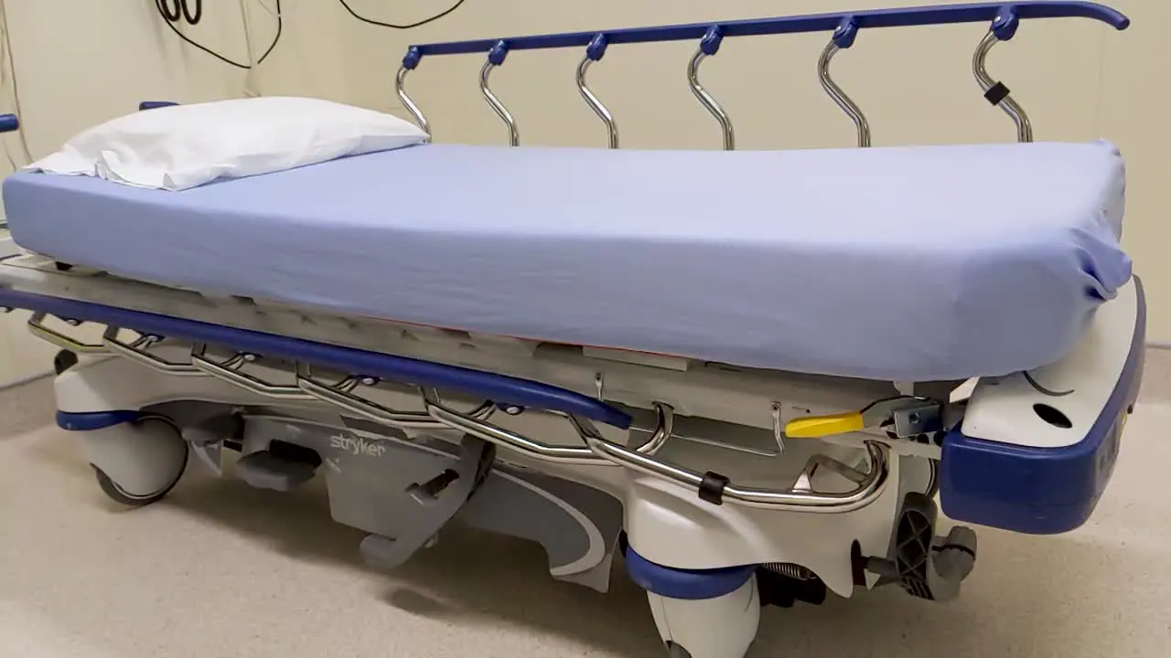 Slow pan left of an empty hospital room ready for a patient to be addressed and processed