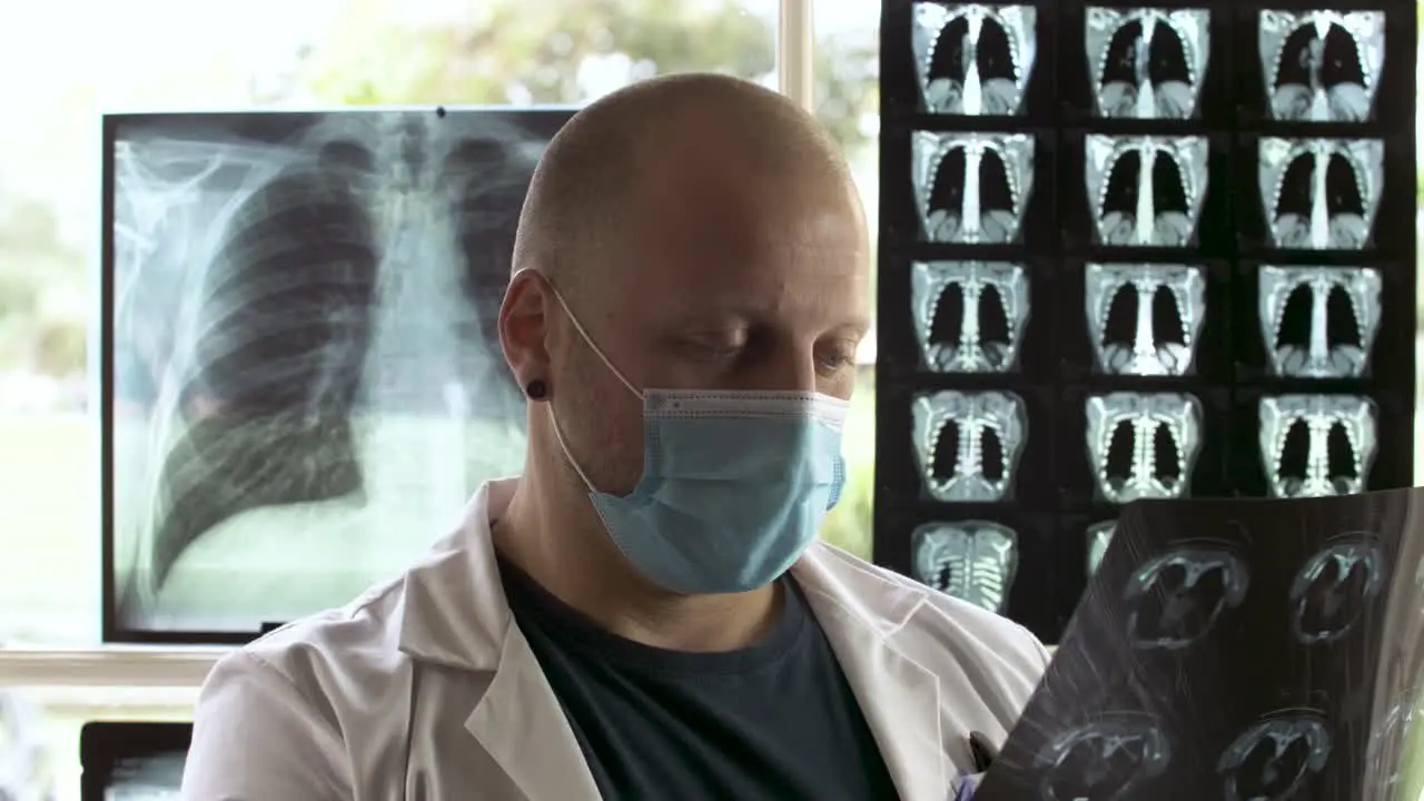 Radiologist doctor with face mask examining an Xray film profile view