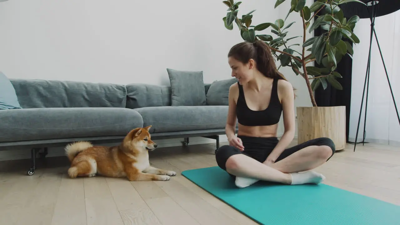 A Girl Takes A Break From Her Yoga Session To Play With Her Cute Dog