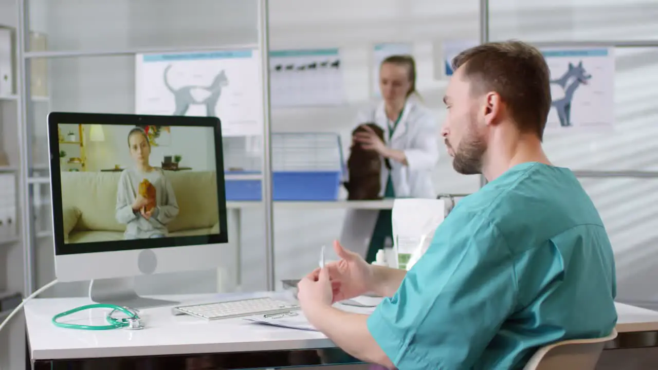 Male Veterinarian Giving Online Consultation Via Video Call And Talking To A Little Girl Holding Her Hamster