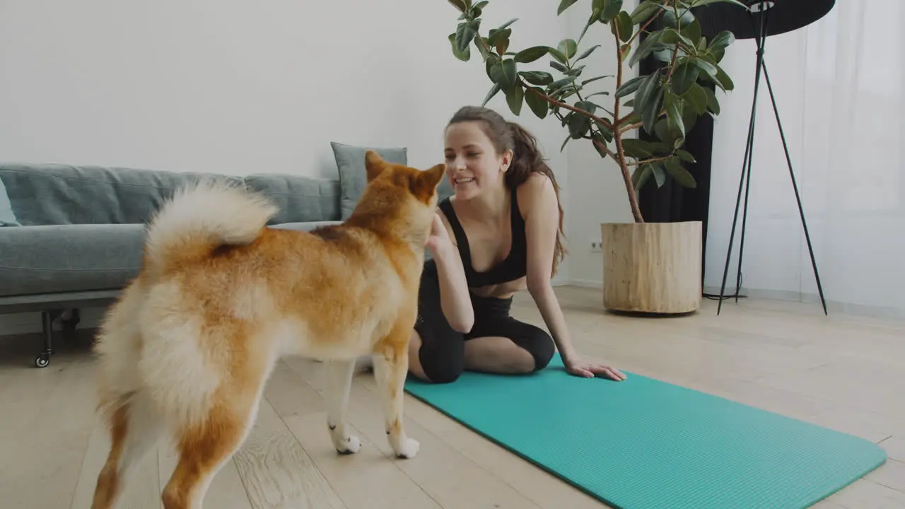 A Girl Takes A Break From Her Yoga Session To Feed Her Cute Dog