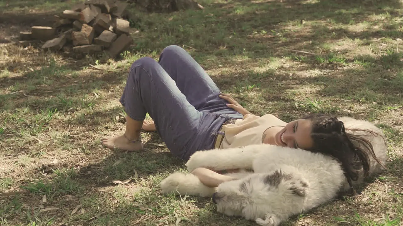 Young Laughing Woman Lying With Her Big Dog On The Grass