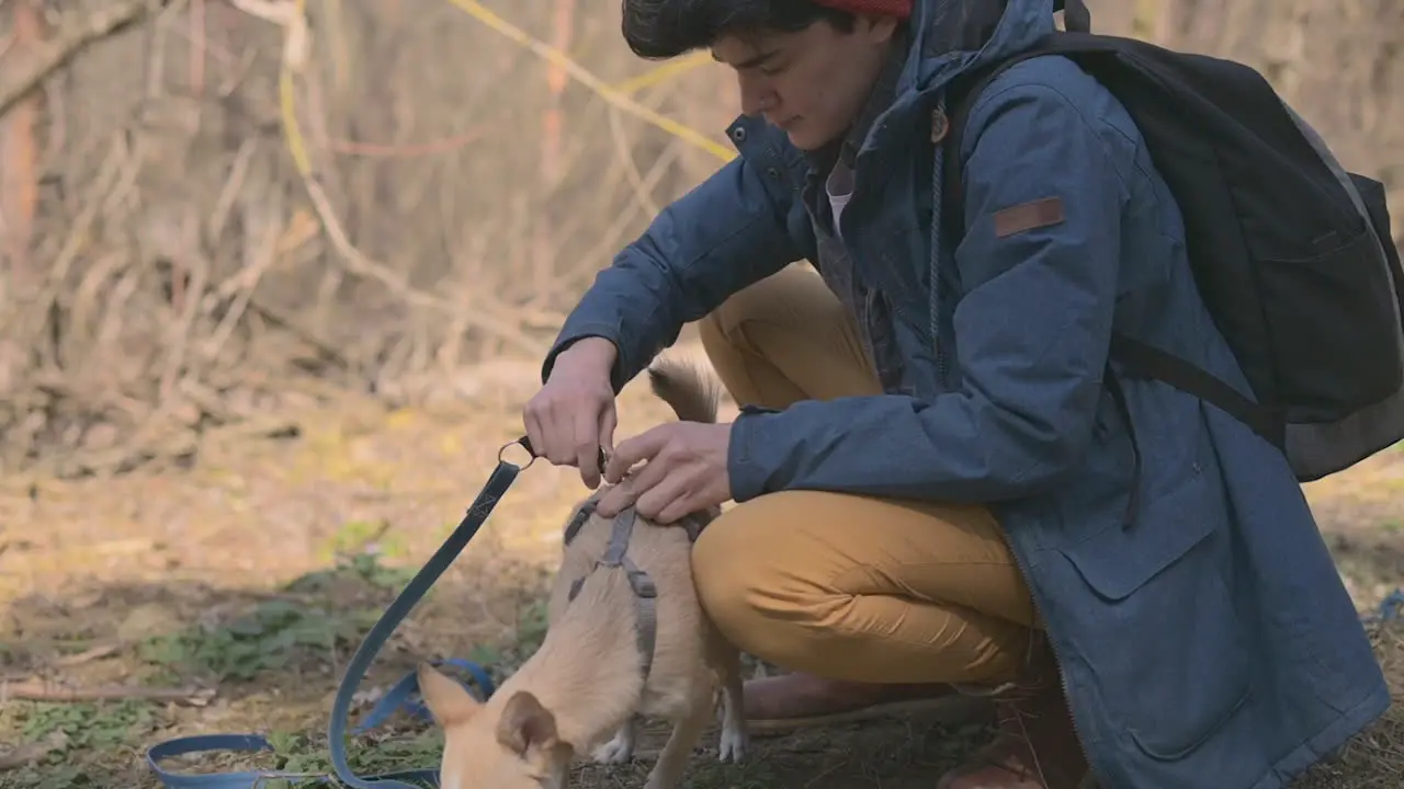 A Woman With Short Hair Puts Her Dog On A Chain Before Going For A Walk In The Woods