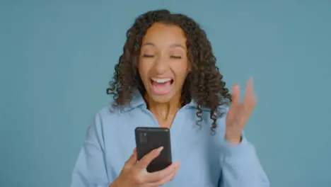 Portrait Shot of Young Adult Woman Celebrating with Smartphone 01