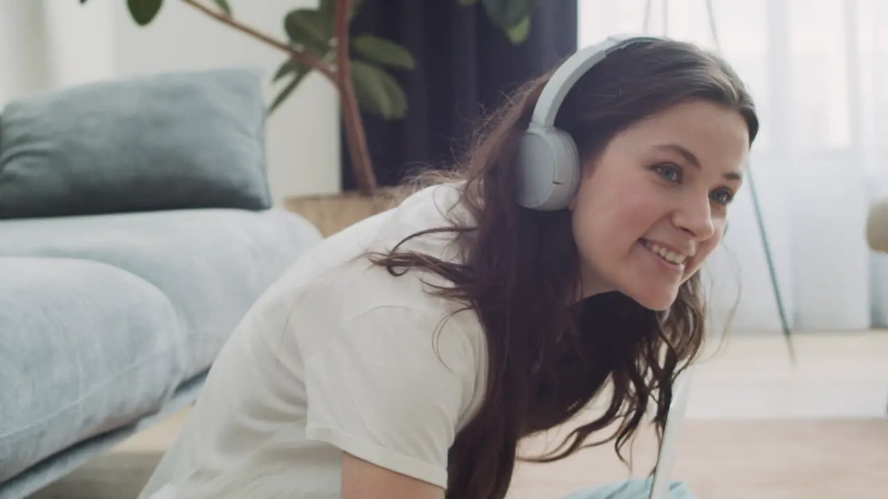 Young Woman Calls Her Dog To Feed Him While Working On Her Laptop At Home 1