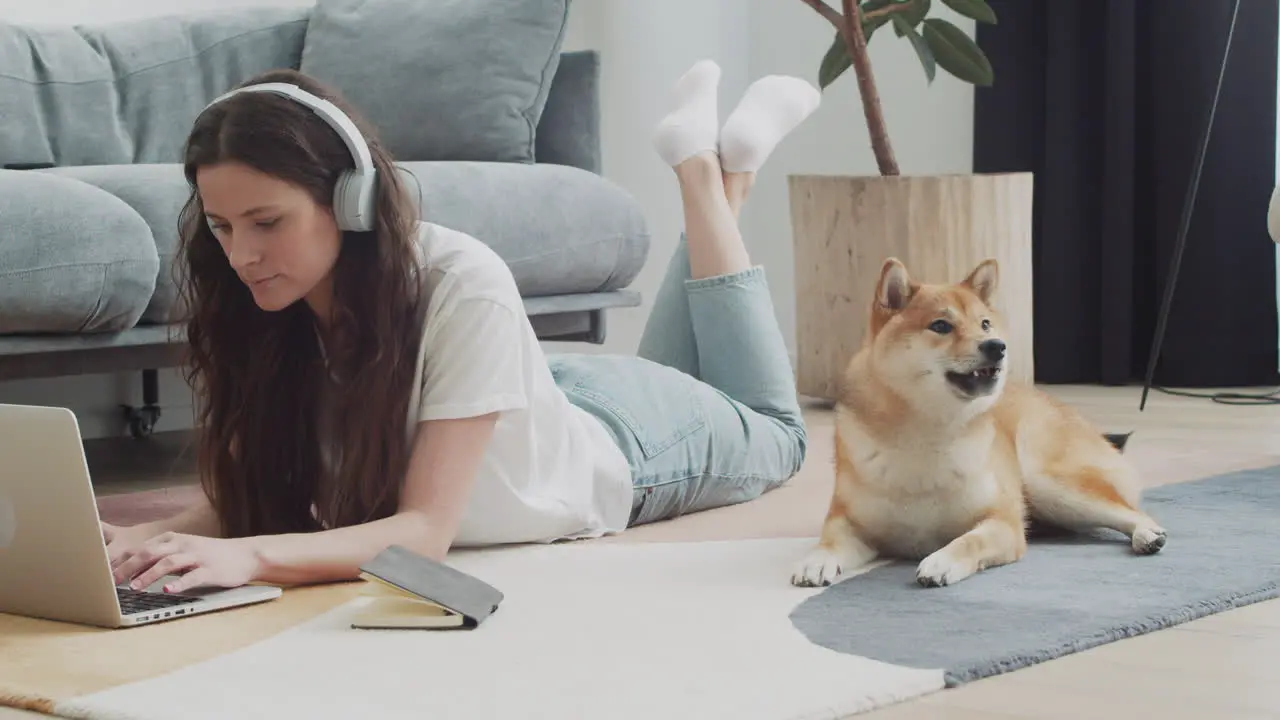 Young Woman Working On Her Laptop At Home Next To Her Dog 4