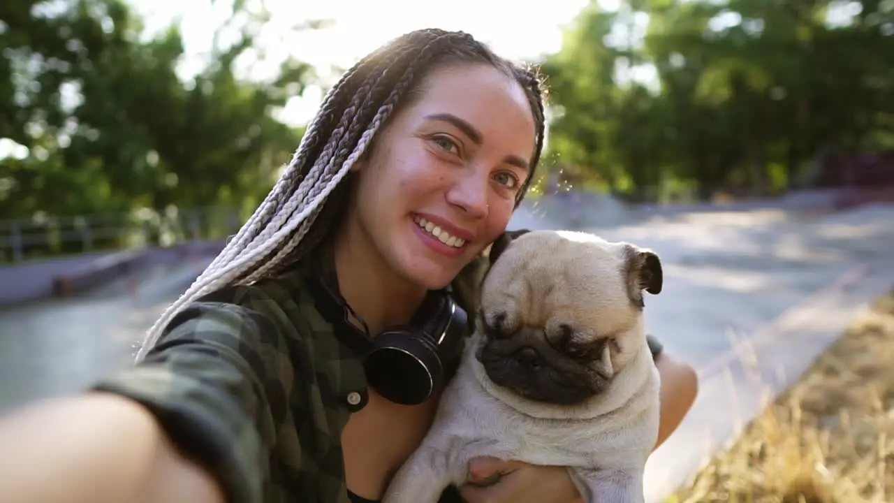 A Cute Beige Pug Puppy Is Trying To Lick The Face