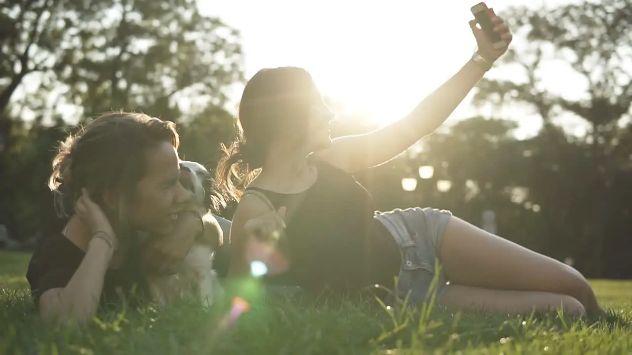 Outdoor Portrait Of Two Female Friends Taking Selfie With A Smartphone