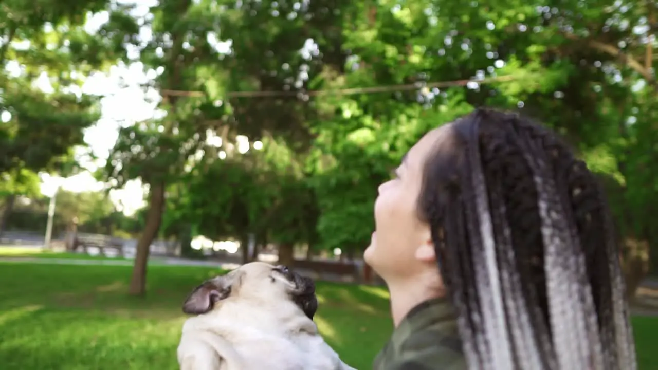 Dreadlocks Woman Happily Throws The Dog In The Air In The Park