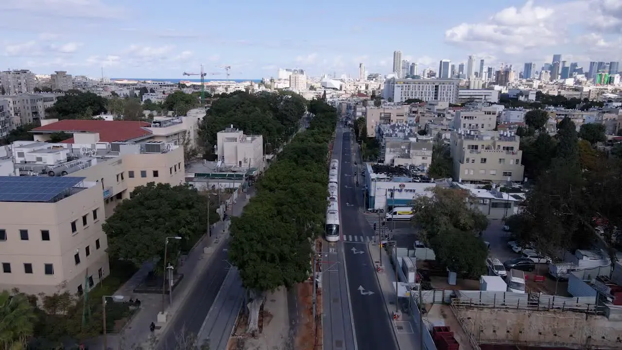 New city train driving through suburban area towards city center of Tel Aviv aerial view