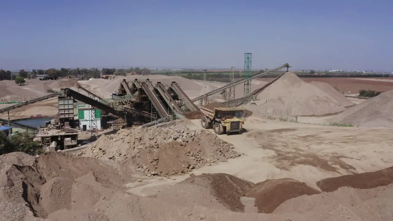 A large truck loaded with sand is heading towards the construction site aerial shots of the truck alongside the construction site and materials