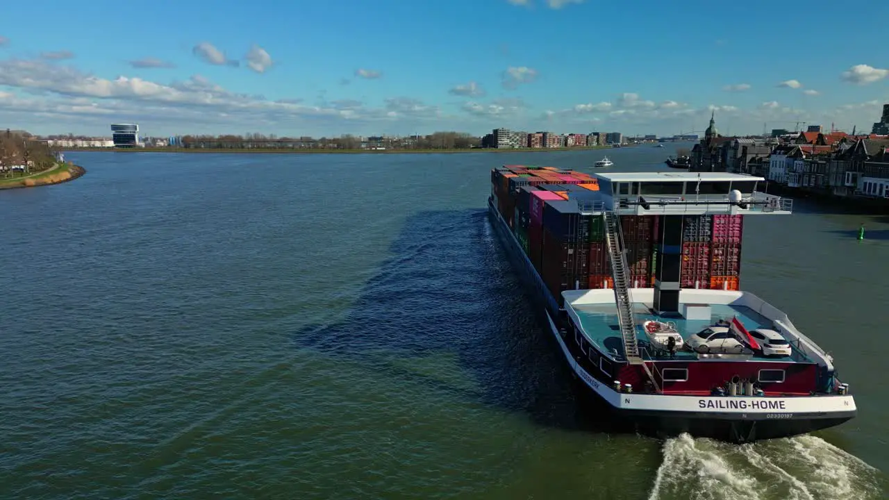 Containership navigating the dutch canal in Doredrecht on a sunny day