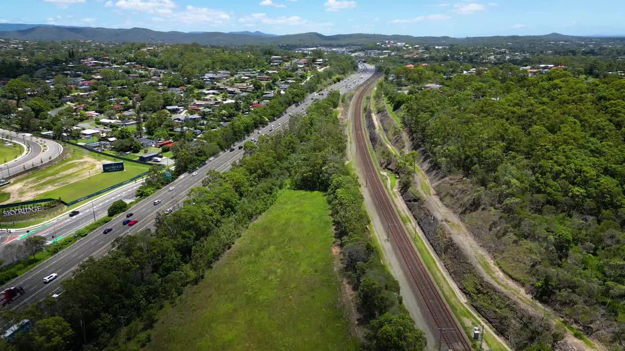 Reversing aerial view over Worongary M1 and rail line near Skyridge development Gold Coast Queensland Australia