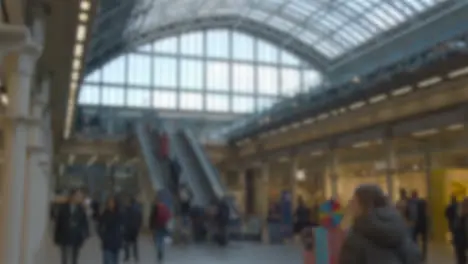 Defocused Shot Of Escalators And Concourse At St Pancras Rail Station In London UK With Commuters