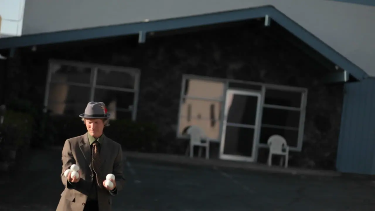 A man starts juggling six balls and drops them all