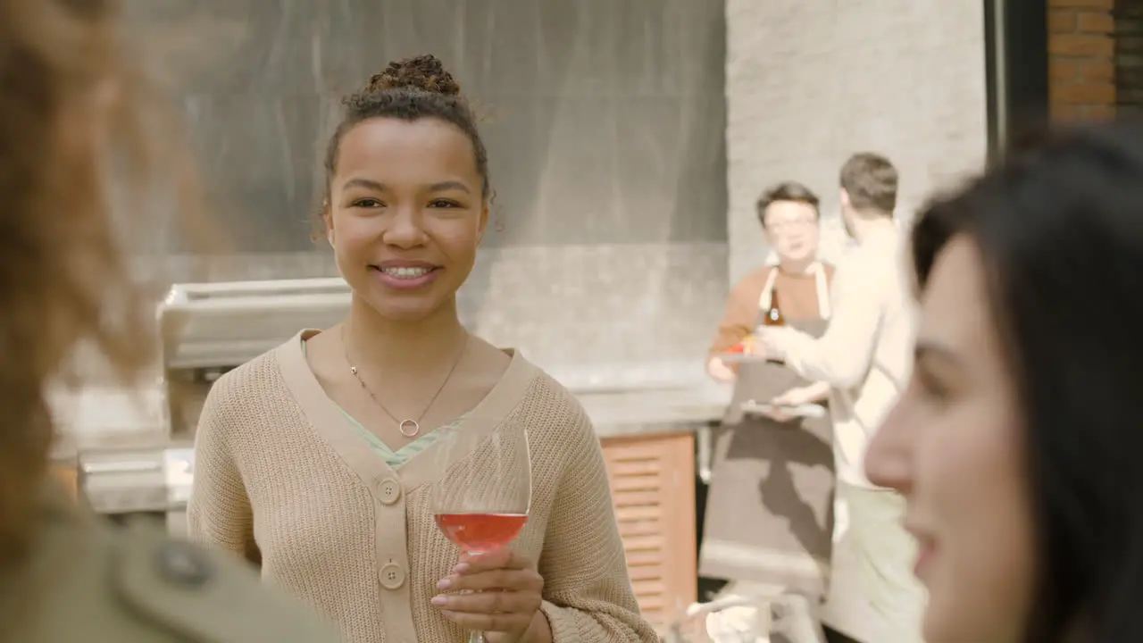 A Beautiful Afroamerican Woman Drinking Wine And Having Fun With Her Friends At A Barbacue